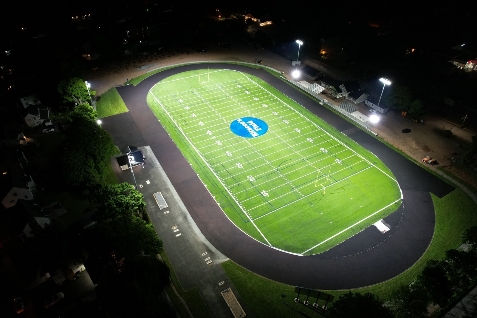 Floodlit turf field glowing at night under high-quality sport lighting